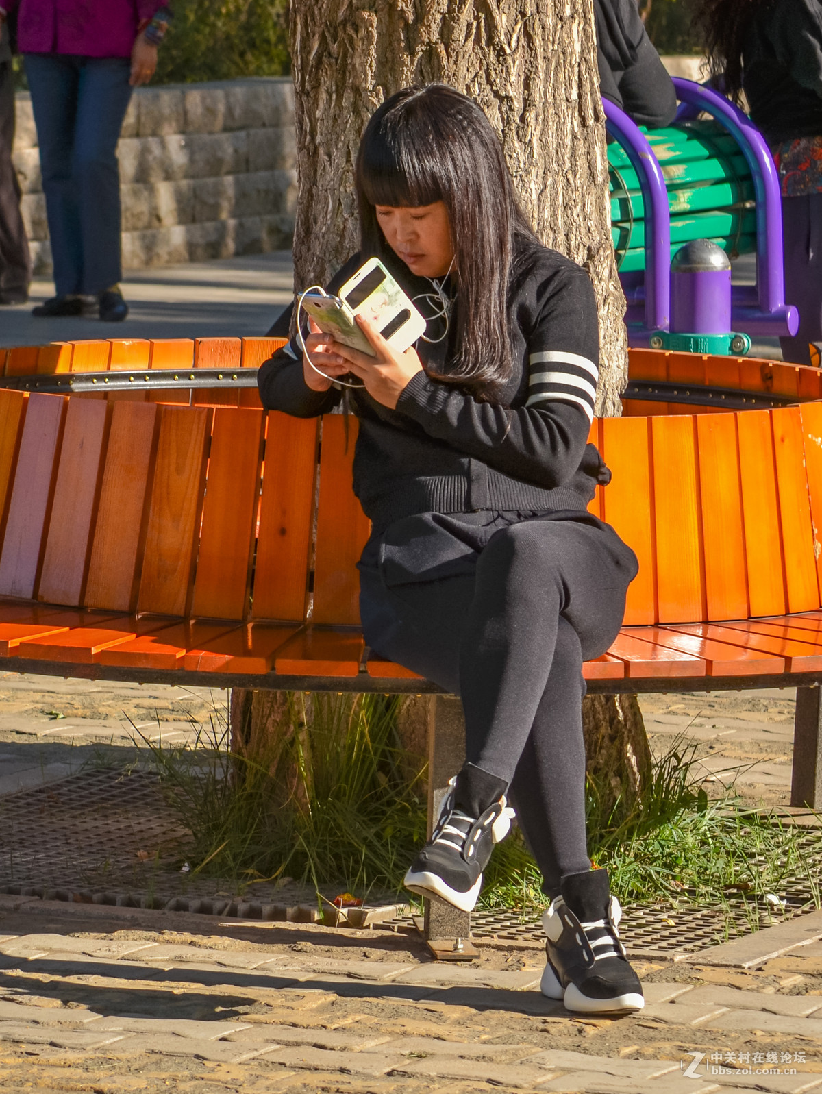 公园里玩手机的女孩子