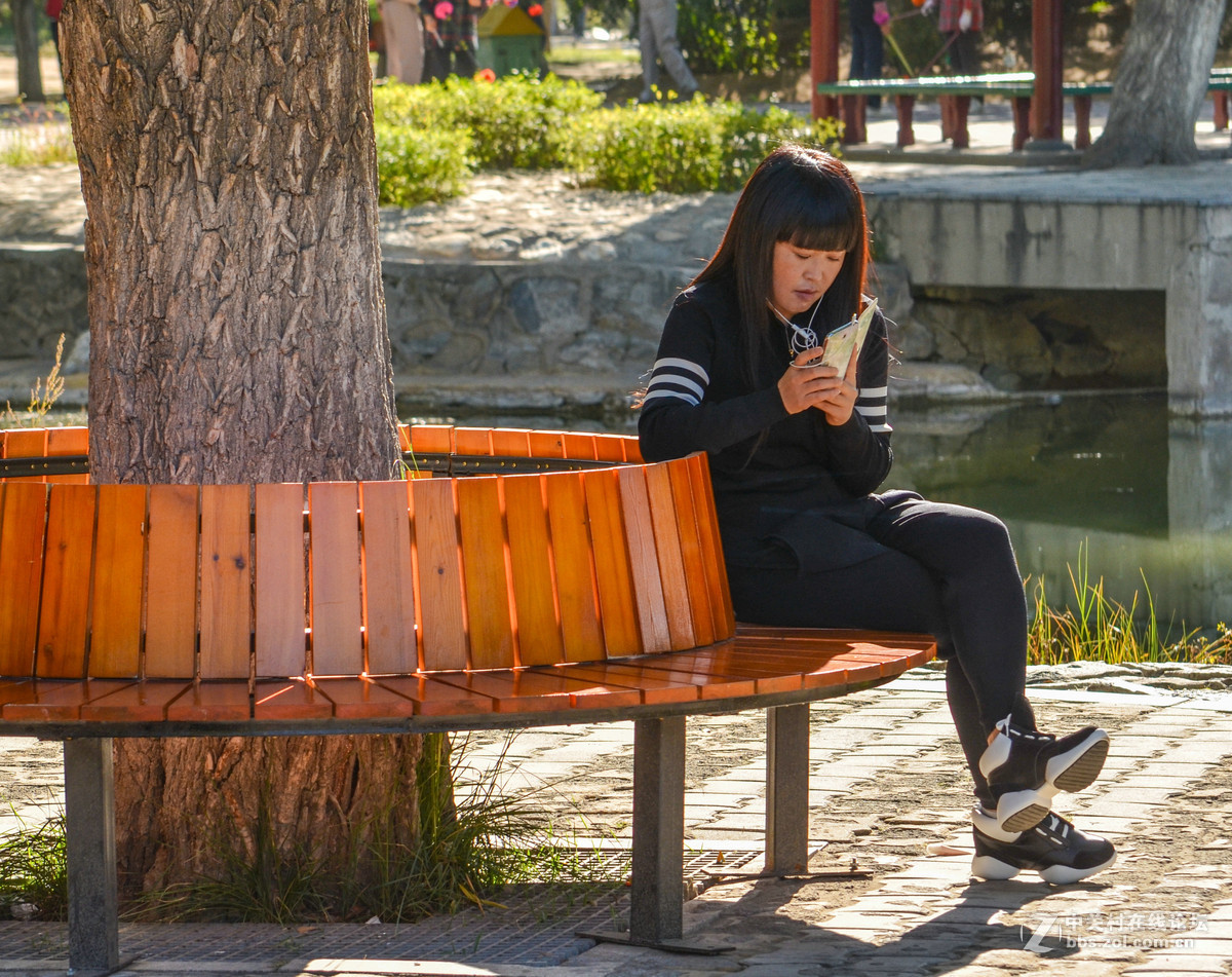 公园里玩手机的女孩子