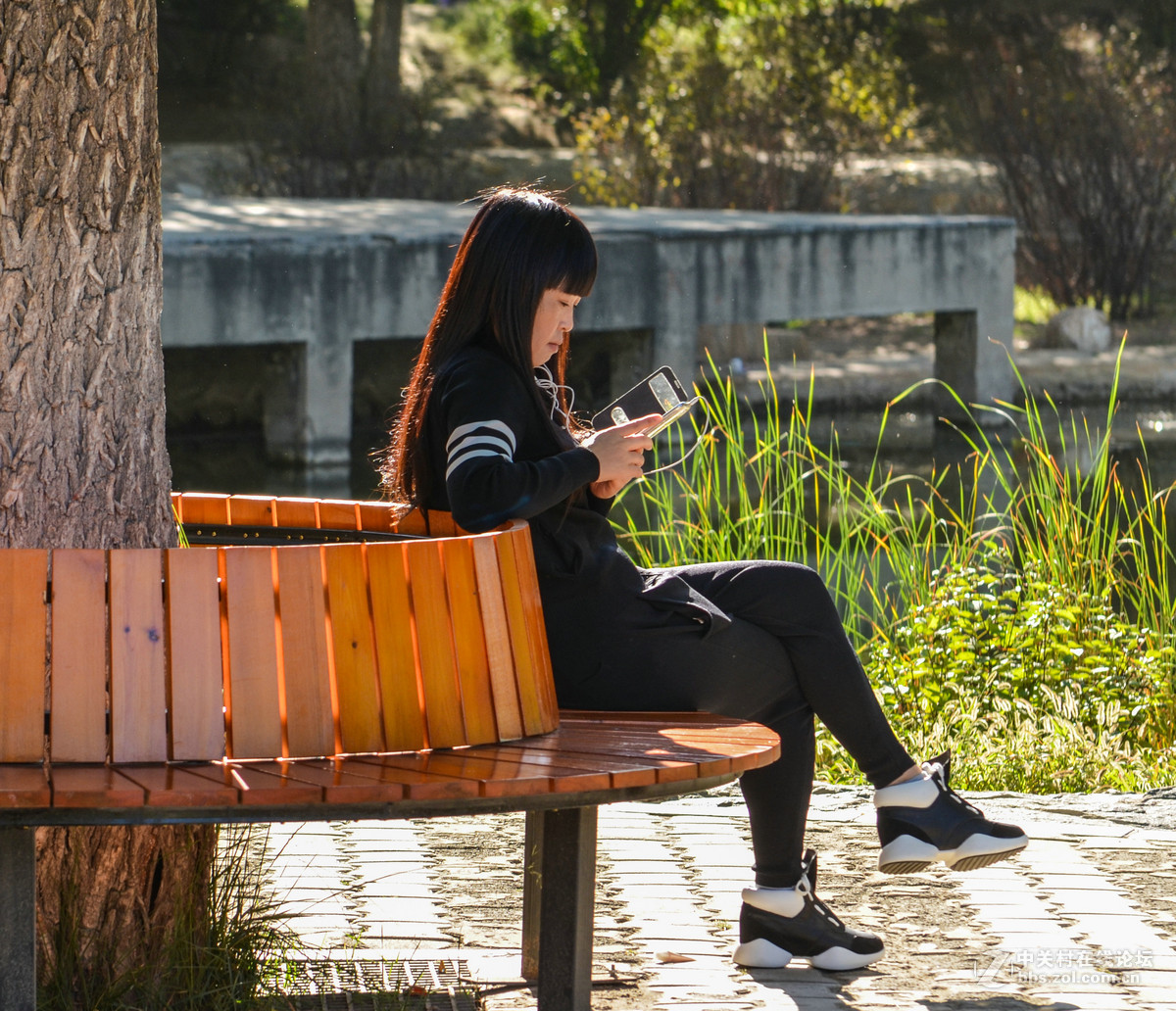 公园里玩手机的女孩子