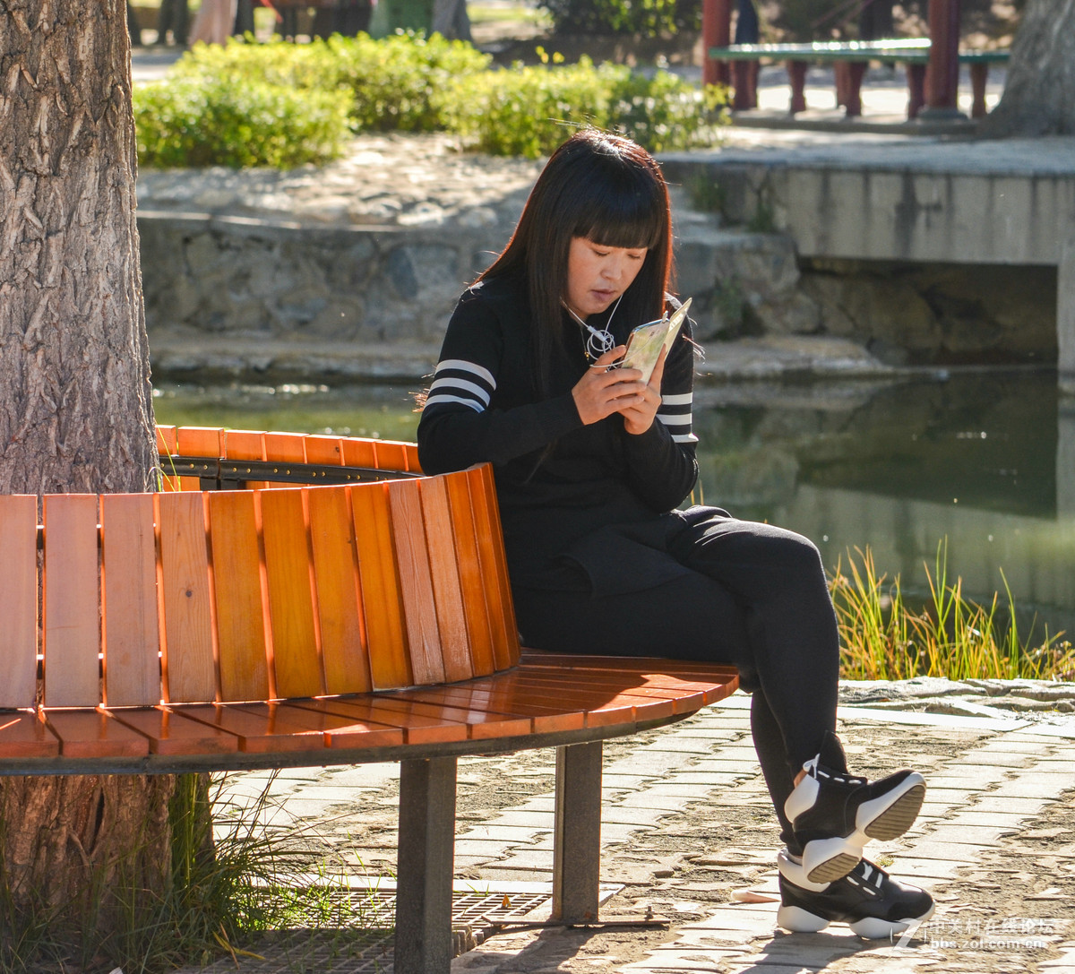 公园里玩手机的女孩子