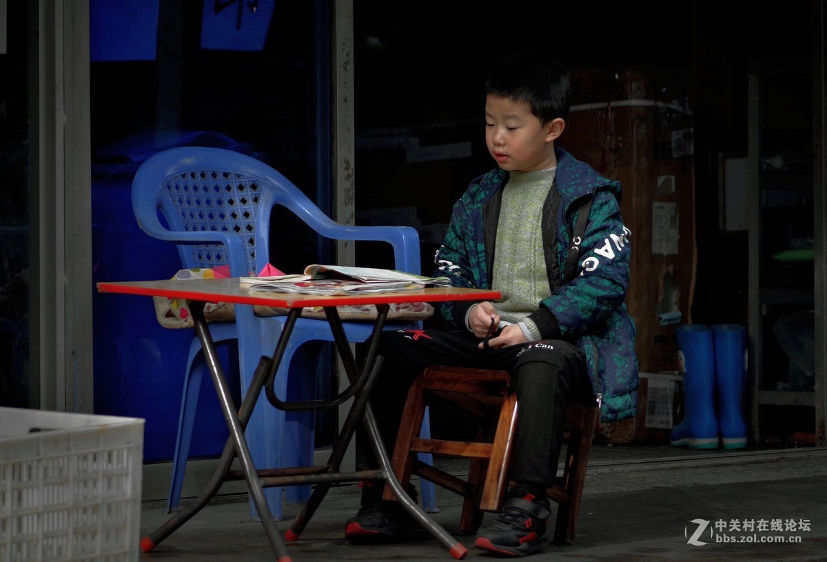 扫街抓拍----屋檐下复习功课的小男孩
