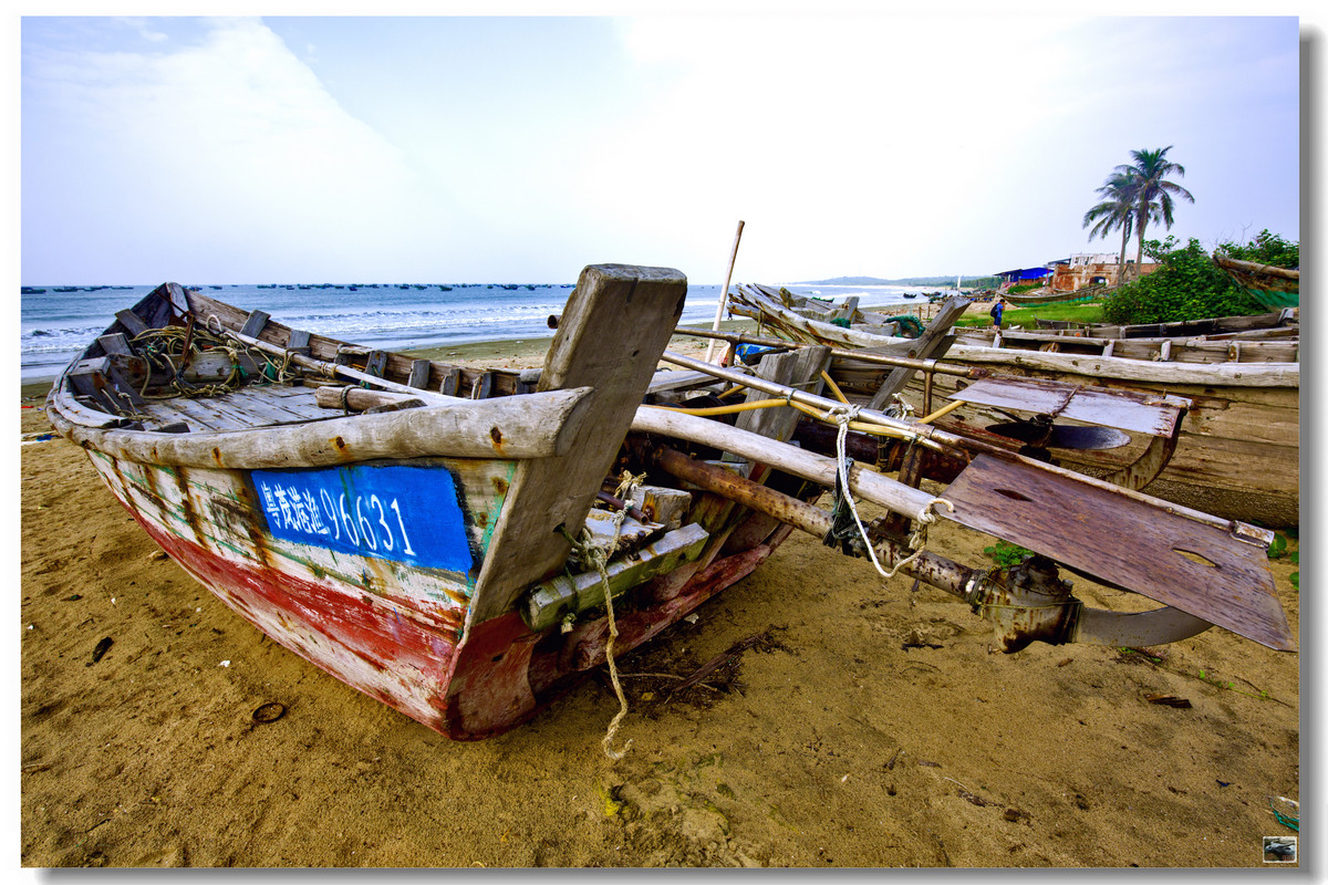 阳光下的海滩与旧渔船