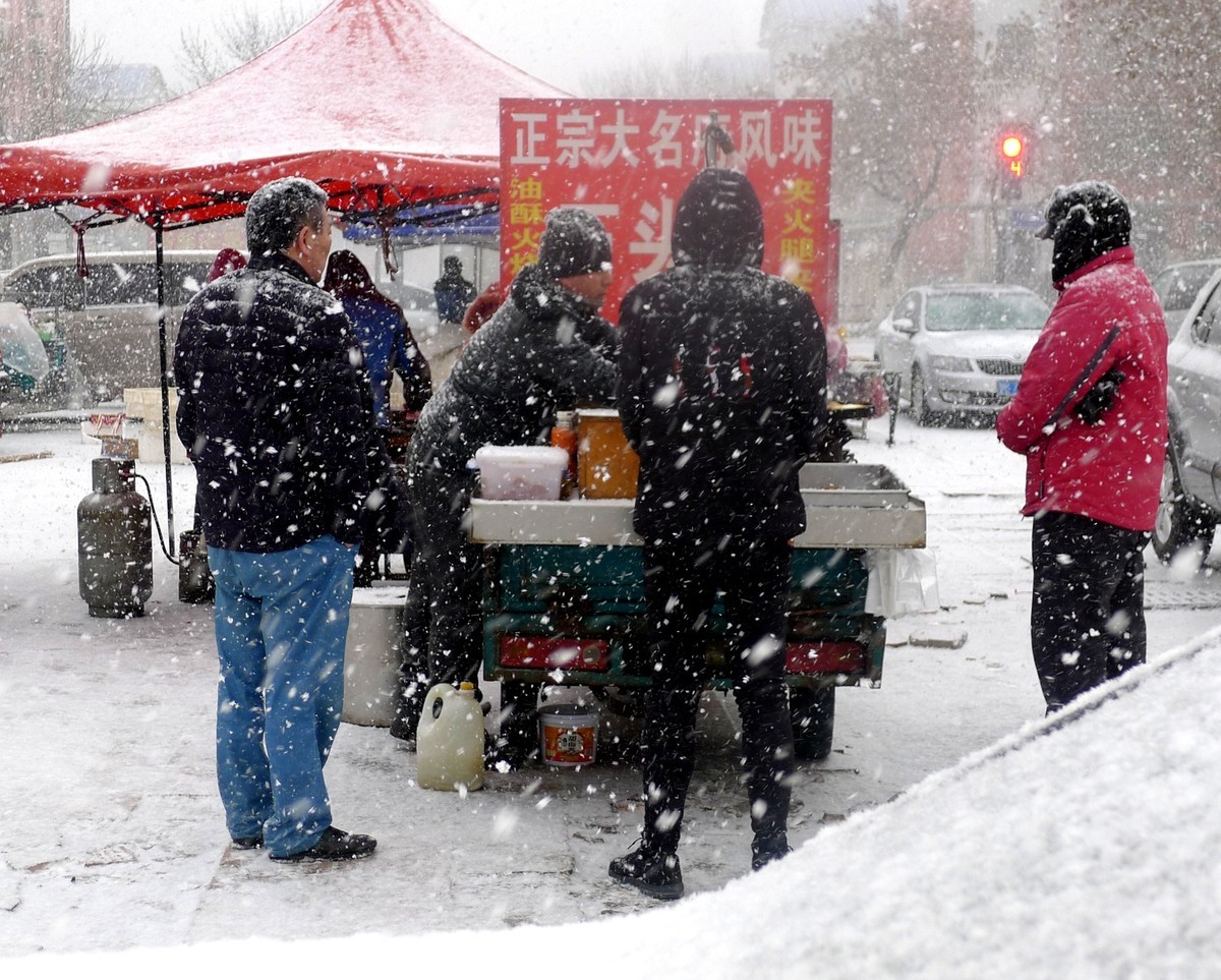 为了生计顶风冒雪摆摊忙