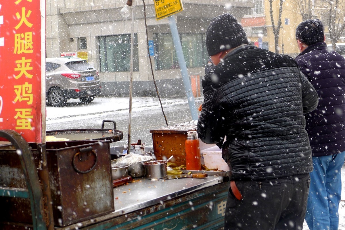 为了生计顶风冒雪摆摊忙