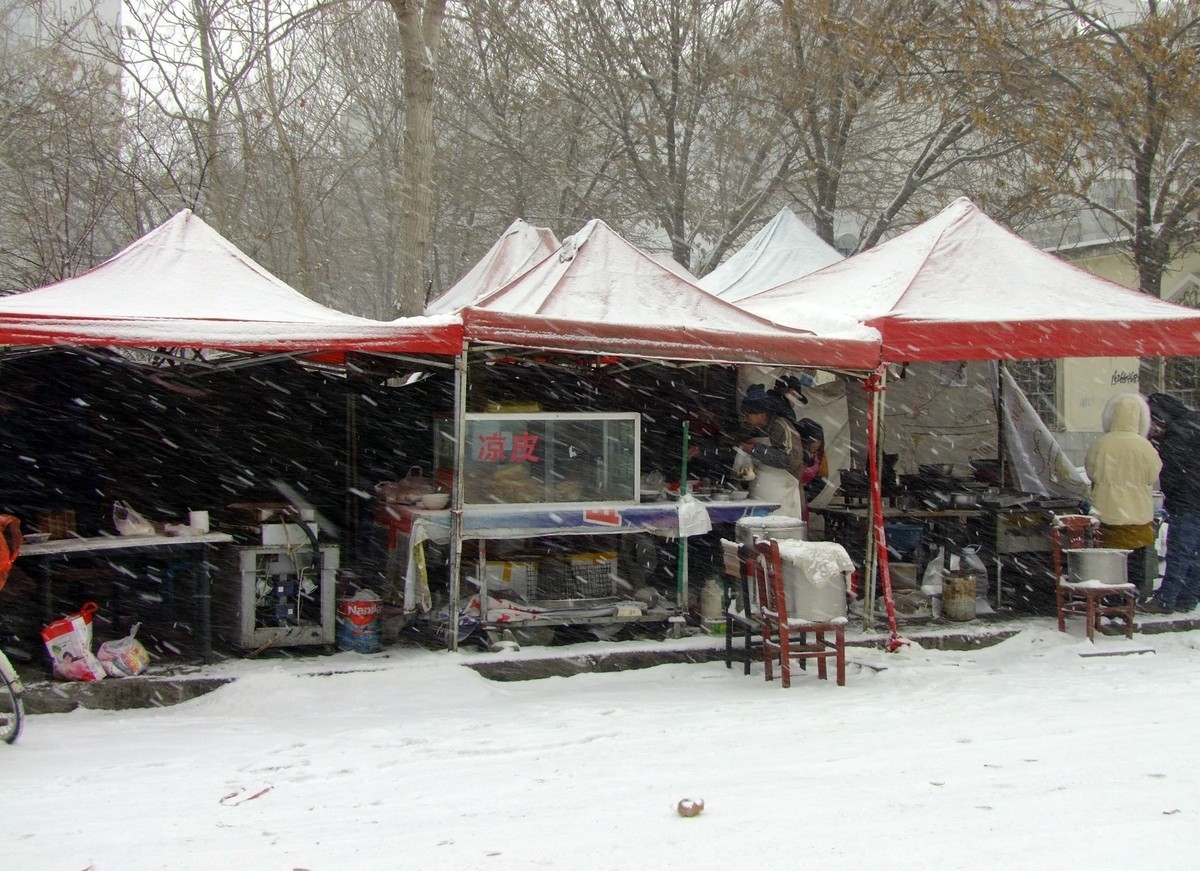 为了生计顶风冒雪摆摊忙