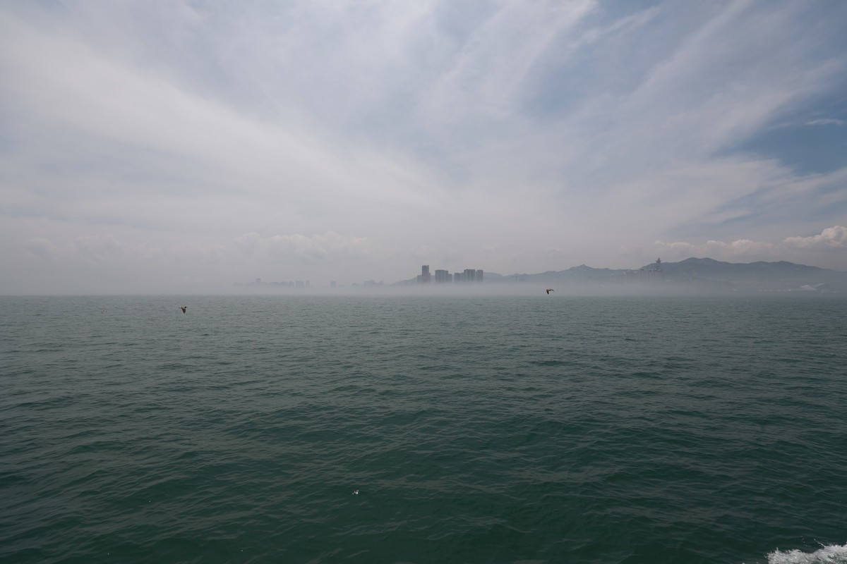 海上起雾了，站在船头的人拍海