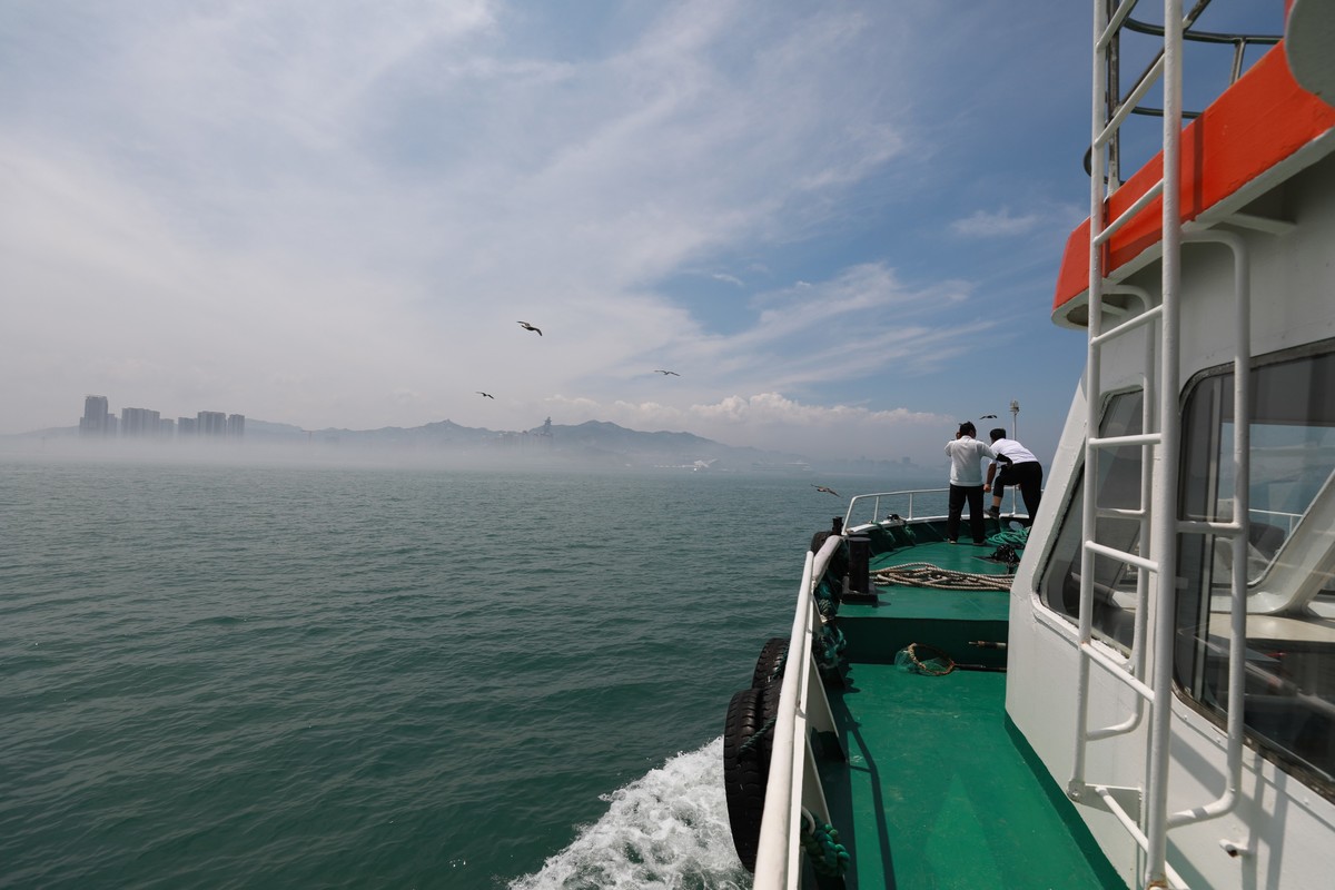 海上起雾了，站在船头的人拍海