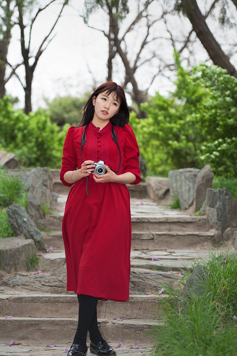 用相机摆拍的红衣女孩