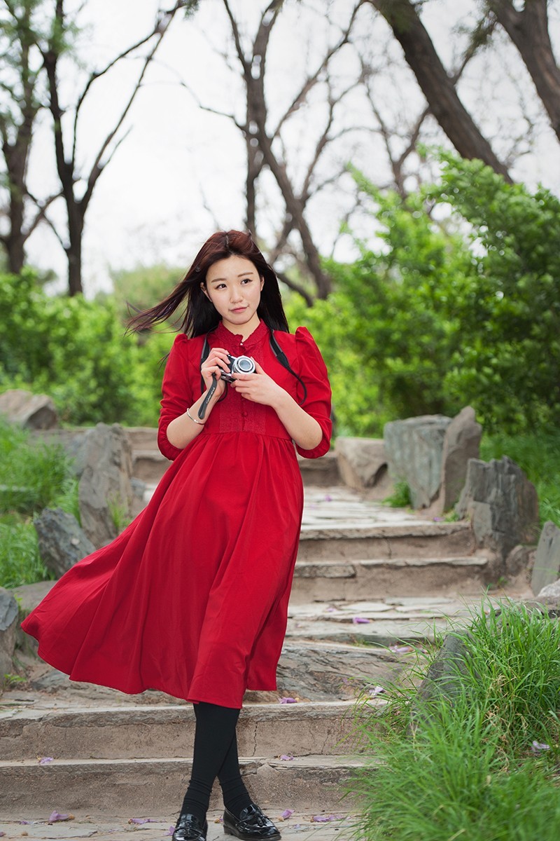 用相机摆拍的红衣女孩