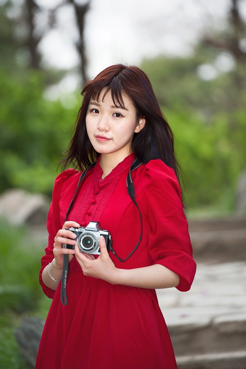 用相机摆拍的红衣女孩