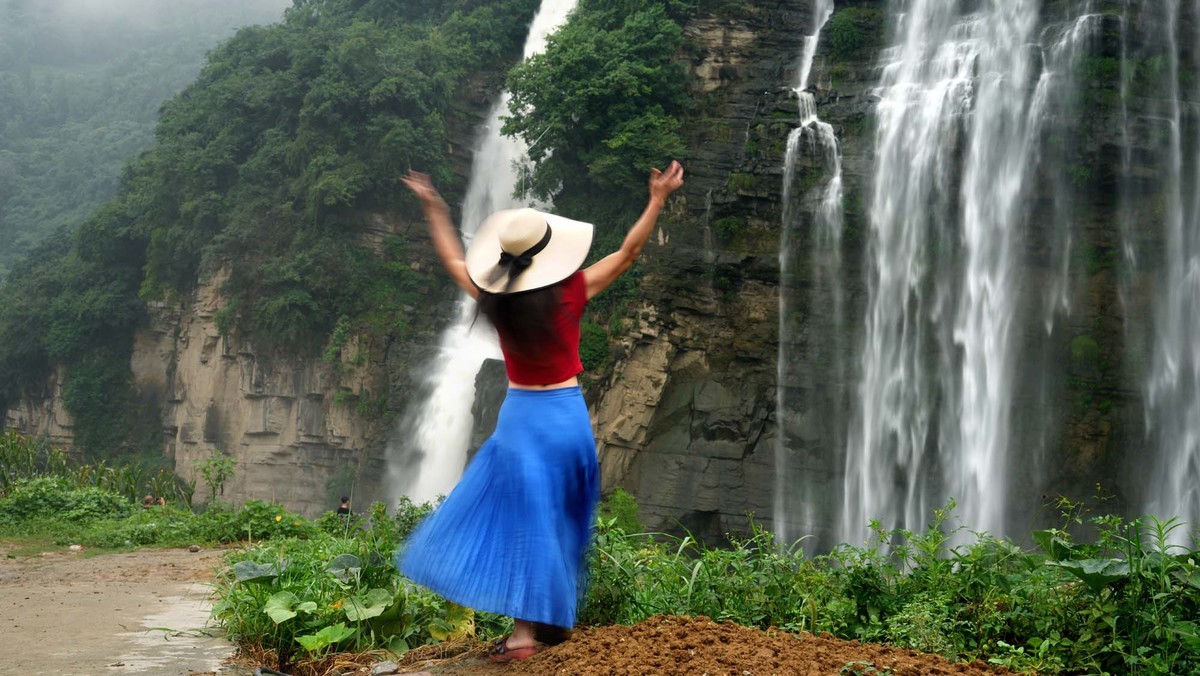 清凉瀑布下的红衣女子