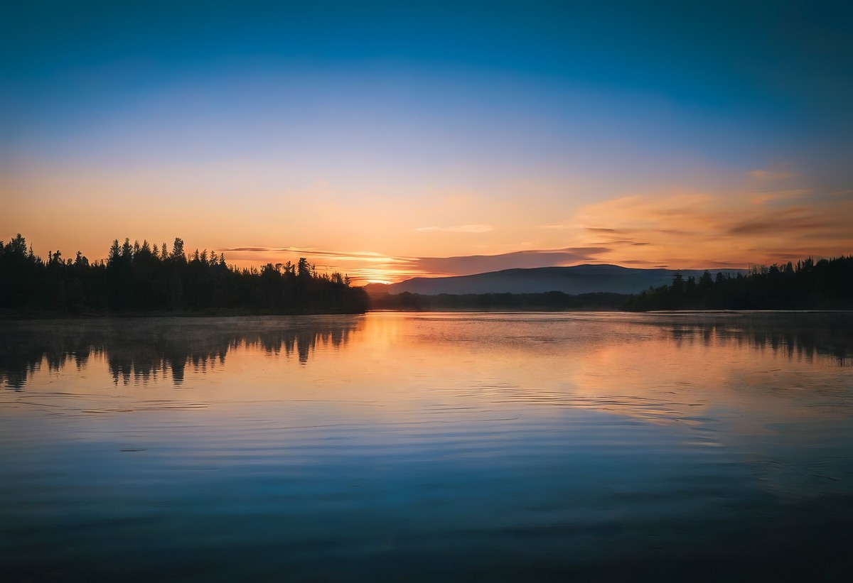 太阳与山影的湖面之舞