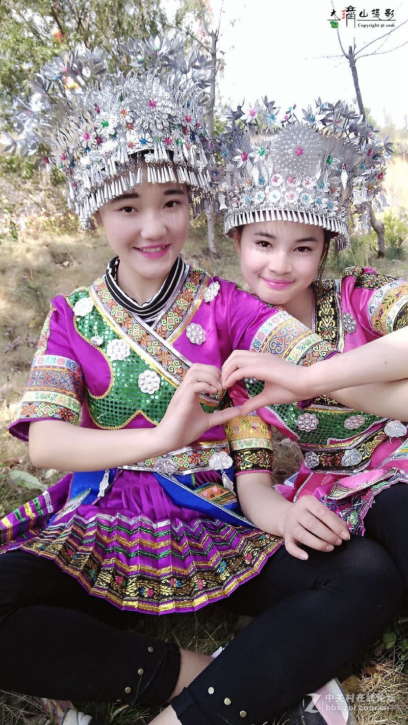 用手机拍穿苗族装的女孩