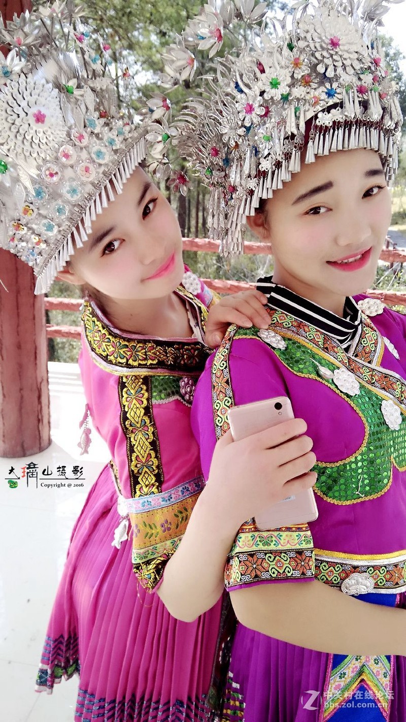 用手机拍穿苗族装的女孩