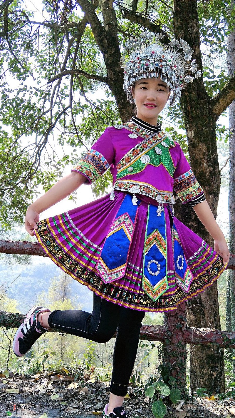 用手机拍穿苗族装的女孩